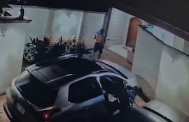 El maleante comienza a acomodar sobre la muralla de la casa, todo los objetos encontrados en el interior de uno de los vehículos, para poder sacarlos de la propiedad con más facilidad.