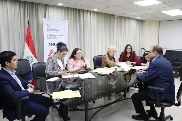 Jorge Rodas en traje oscuro, junto a doctoras Ana Campuzano y Sandra Ocampos, sentados alrededor de una mesa, con seriedad en sus rostros.