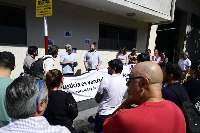 Grupo de personas en asamblea frente a la Municipalidad, con banner que dice 'Justicia es verdad'.