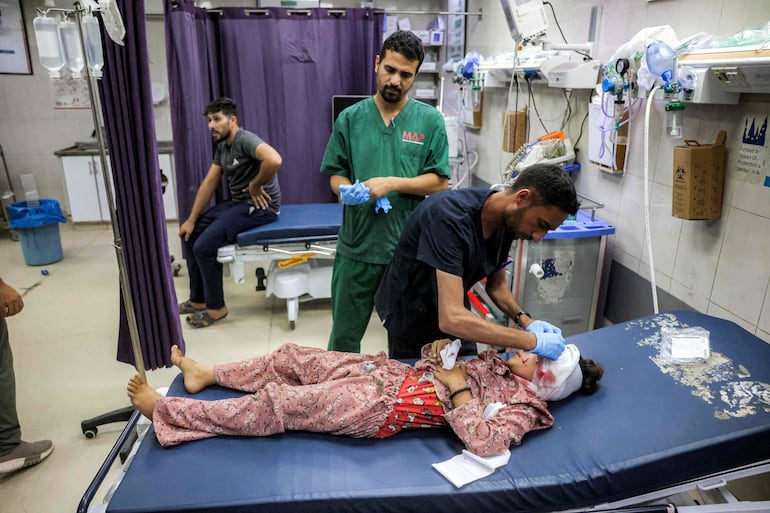 Médicos atienden a un niño herido en un hospital en Jan Yunis, en el sur de la Franja de Gaza, luego de un bombardeo israelí en la zona, el pasado 7 de julio.