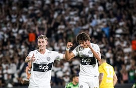 El delantero de Olimpia, Adrián Alcaraz (26 años) celebra el tanto que le dio el triunfo a Olimpia en el clásico blanco y negro ante Libertad, lo acompaña el volante Juan Fernando Alfaro. (Foto: @elClubOlimpia)