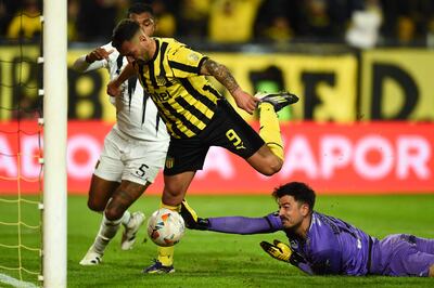 Penarol's forward Facundo Batista scores past The Strongest's goalkeeper Guillermo Viscarra during the Copa Libertadores round of 16 first leg football match between Uruguay's Peñarol and Bolivia's The Strongest at the Campeon del Siglo stadium, in Montevideo, on August 14, 2024. (Photo by DANTE FERNANDEZ / AFP)