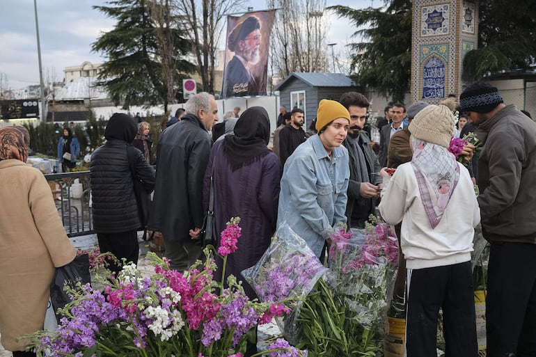 Una mujer compra flores en el bazar de Tajrish en el norte de Teherán en el día Noruz, el año nuevo persa. Miles de iraníes desafiaron las bombas y la lluvia y se acercaron al bazar de Tajrish para realizar las compras típicas de Noruz -año nuevo persa- que se celebra hoy en medio de una guerra que se alarga ya por 21 días.