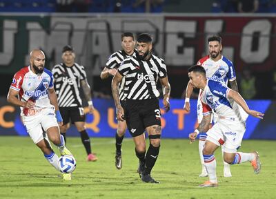 Alexander Barboza (c), jugador de Libertad, pelea por el balón en el partido contra Fortaleza por la ida de los octavos de final de la Copa Sudamericana en el estadio Defensores del Chaco, en Asunción.