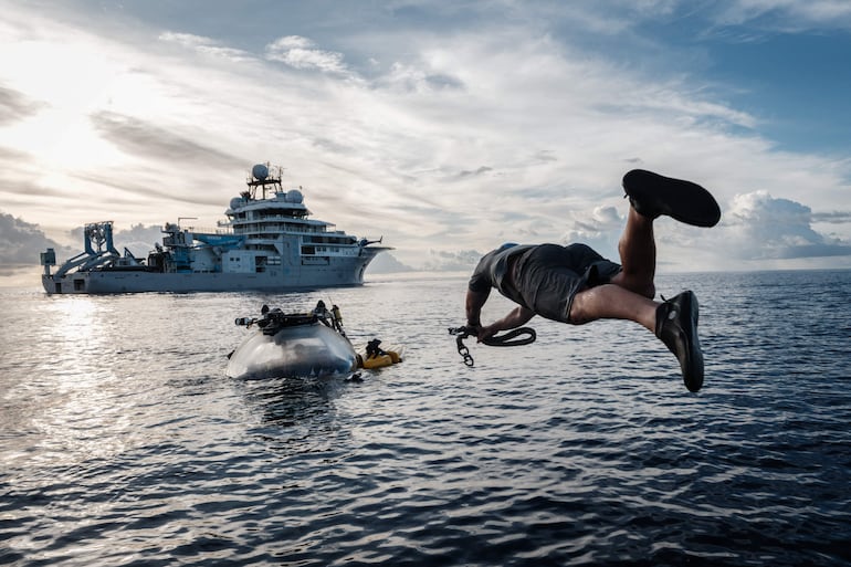 Esta foto, tomada el 9 de enero de 2026, muestra a la tripulación del OceanXplorer, un buque de investigación operado por la organización marina sin fines de lucro OceanX, saltando al mar desde una embarcación para nadar hacia un sumergible que ha salido a la superficie y colocar una línea de recuperación, en aguas frente a la isla de Célebes (Sulawesi).
