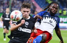 Arkadiusz Pyrka (i), de FC St. Pauli, disputa el balón con Jordan Torunarigha, del Hamburgo SV, durante el encuentro disputado este viernes por la segunda fecha de la Bundesliga 2025/216.  (EFE).
