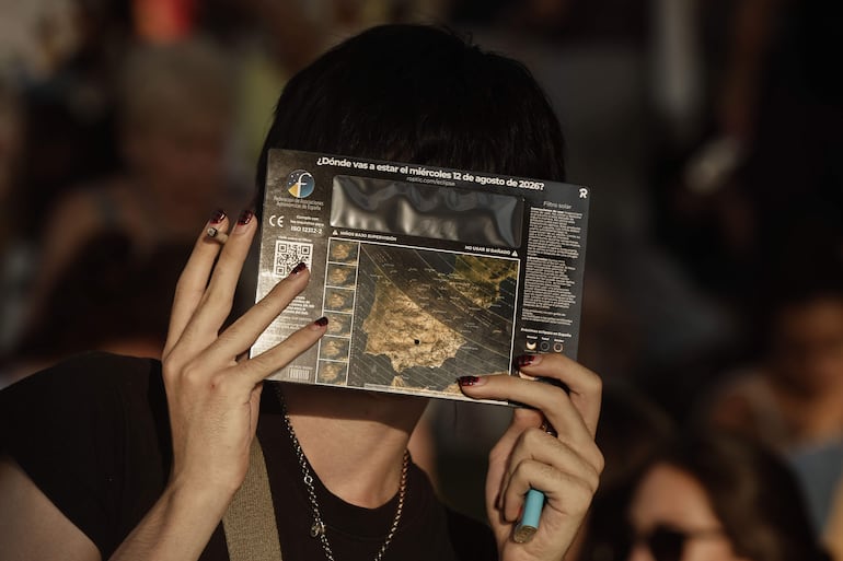Una mujer espera con gafas protectoras el comienzo del eclipse de Sol en Madrid este miércoles.