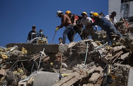 Personas trabajan en labores de rescate en una edificación colapsada por el terremoto de magnitud 7,4 que sacudió al país este lunes, en Cali (Colombia). EFE