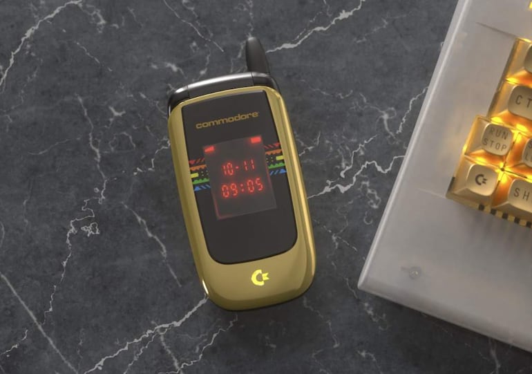 Teléfono móvil Commodore de diseño retro sobre superficie de mármol, con teclado visible al lado y logotipo de la marca.