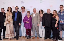 Grupo de diez personas posando en festival, con variedad de vestimenta, sonrisas y una atmósfera festiva.