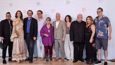 Grupo de diez personas posando en festival, con variedad de vestimenta, sonrisas y una atmósfera festiva.
