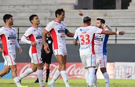El mediapunta de Nacional, Josué Colmán recibe las felicitaciones de sus compañeros tras anotar de penal el segundo tanto "tricolor" en el triunfo ante Libertad.