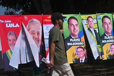 AME1288. BRASILIA (BRASIL), 30/09/2026.- Un hombre camina frente a una tienda informal de banderas con la imagen del presidente de Brasil y candidato a la reelección, Luiz Inácio Lula da Silva y del candidato presidencial, Flávio Bolsonaro, este lunes en Brasilia (Brasil). Mientras las encuestas hablan de una extrema igualdad entre el presidente progresista Luiz Inácio Lula da Silva y el ultraderechista Flávio Bolsonaro, analistas consideran que el resultado de las elecciones brasileñas del 4 de octubre depende de un amplio sector que observa el proceso con distancia y escepticismo: los indecisos. EFE/Andre Borges