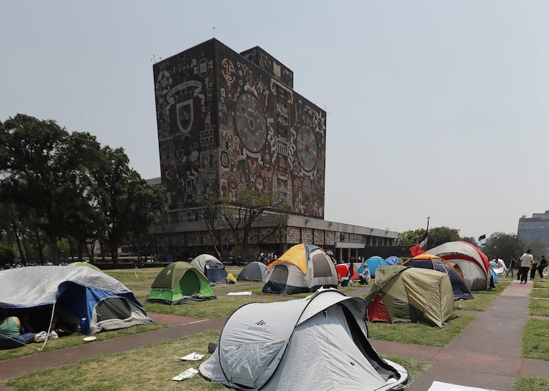 Fotografía de archivo del 03 de mayo de 2024 que muestra a estudiantes protestando en tiendas de campaña frente a las instalaciones de la Universidad Nacional Autónoma de México (UNAM), en Ciudad de México (México). La UNAM, la mayor institución pública de educación superior del país, enfrenta una de las mayores controversias de los últimos años luego de que se detectaran presuntas irregularidades en su primer examen de admisión aplicado completamente en línea. 