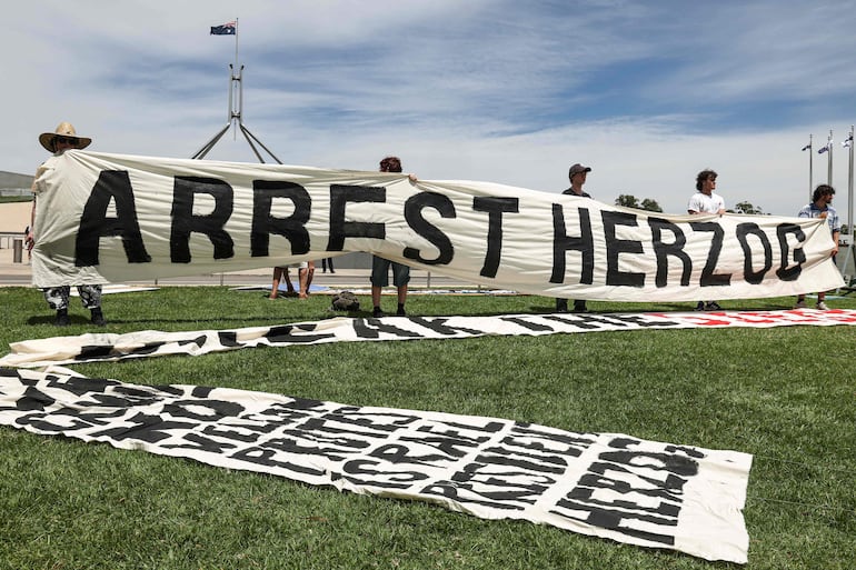Protesters gather in front of the Parliamment House building ahead of the meeting between Australia's Prime Minister Anthony Albanese and Israel's President Isaac Herzog in Canberra on February 11, 2026. Herzog's tightly secured, four-day trip aims to console Australia's Jewish community after the December shooting at Sydney's Bondi Beach that killed 15 people at a Hanukkah festival. (Photo by David GRAY / AFP)