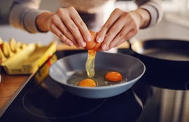 Mujer cocina huevos.