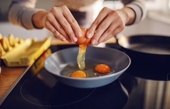 Mujer cocina huevos.