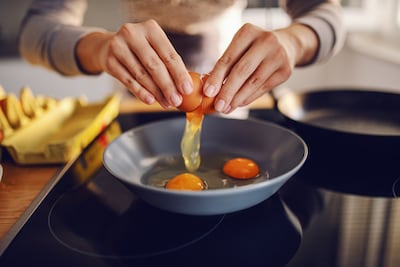 Mujer cocina huevos.
