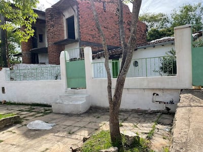 Entorno descuidado con construcción en abandono y pavimento visible, en un área urbana sin actividad humana.