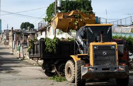 Un tractor carga ramas podadas en un camión antes de la llegada de la tormenta tropical Melissa a Santiago de Cuba el 25 de octubre de 2025.