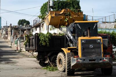 Un tractor carga ramas podadas en un camión antes de la llegada de la tormenta tropical Melissa a Santiago de Cuba el 25 de octubre de 2025.