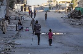 Un hombre palestino amputado camina con su hija por la calle Al Jalaa durante una operación militar israelí en la ciudad de Gaza, Franja de Gaza, el 6 de octubre de 2025. Según la ONU, alrededor del 90 % de la población de Gaza, o 1,9 millones de personas, se ha visto desplazada desde el inicio del conflicto.