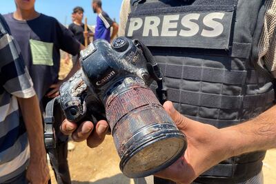Un periodista muestra la cámara ensangrentada de uno de los reporteros fallecidos ayer en un bombardeo israelí al hospital Nasser, en Jan Yunis.