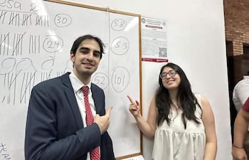 Silvia Antonella Ovelar Ayala sonríe en blusa clara y Alejandro Ovelar Ayala en traje oscuro, ambos frente a pizarra blanca.