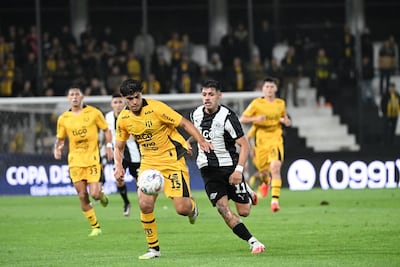 El zaguero de Guaraní, Thiago Servín domina el esférico ante la presión del delantero de Libertad, Elvio Vera.