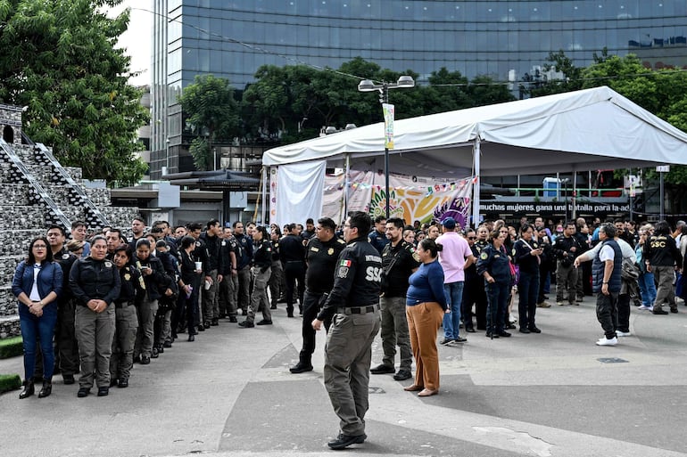 Trabajadores de la Secretaría de Seguridad Ciudadana de México permanecen fuera de la sede de la agencia tras una evacuación preventiva luego de un terremoto de magnitud 7.3 que sacudió el sur de México y partes de Centroamérica.