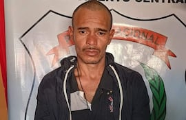 Alcides Rolando Ayala Lovera 'Chino', con expresión seria, esposado, vestido con camiseta oscura, en ambiente policial.