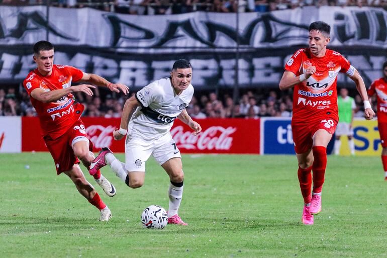 Hugo Fernández, jugador de Olimpia, pelea por el balón en un partido ante Sportivo Ameliano por el torneo Apertura 2024 del fútbol paraguayo en el estadio Osvaldo Domínguez Dibb, en Asunción.