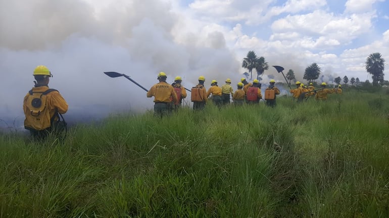 Militares y bomberos voluntarios trabajan incansablemente para sofocar el incendio en Villa Hayes.