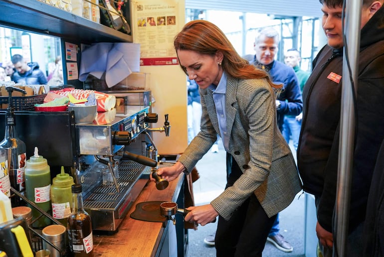 La princesa de Gales, Kate Middleton, preparando un capuchino para el príncipe William durante una visita al mercado de Borough en Londres. (Arthur Edwards / POOL / AFP)