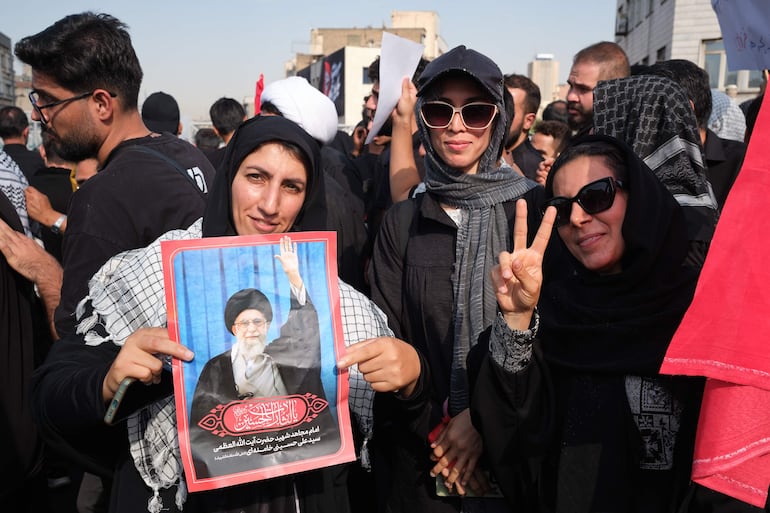Unas jóvenes posan en la procesión funeraria del asesinado líder supremo Alí Jameneí en Teherán. Millones de iraníes participaron este lunes en la procesión fúnebre del asesinado líder supremo Alí Jameneí, con gritos de venganza por su muerte en el primer día de la guerra con Israel y Estados Unidos, el 28 de febrero.