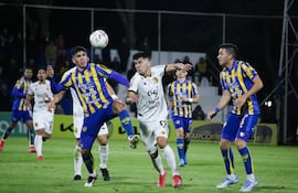 El delantero de Guaraní, Richar Torales intenta zafar de la marca del zaguero central de Sportivo Luqueño, Alexis Villalba.