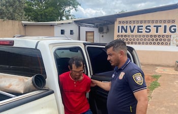 El detenido Gregorio Gabilan (60), custodiado por un agente policial de Capitán Bado.