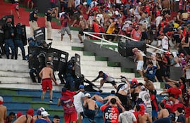 Policías antidisturbios e hinchas de Cerro Porteño se enfrentan en el estadio Defensores del Chaco.