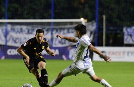 Sergio Fretes, volante de Ameliano, intenta cortar el pase ejecutado por Agustín Manzur.