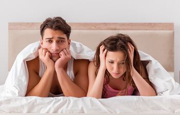 Pareja frustrada en la cama.