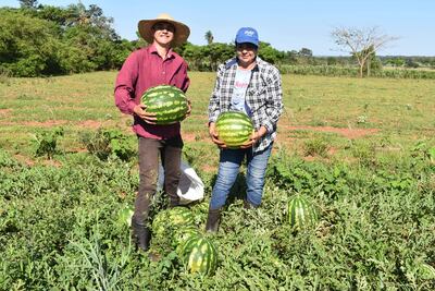La señora Felicia Gomez y su hijo Leandro exhiben las frutas de sandía cosechadas en la finca familiar 