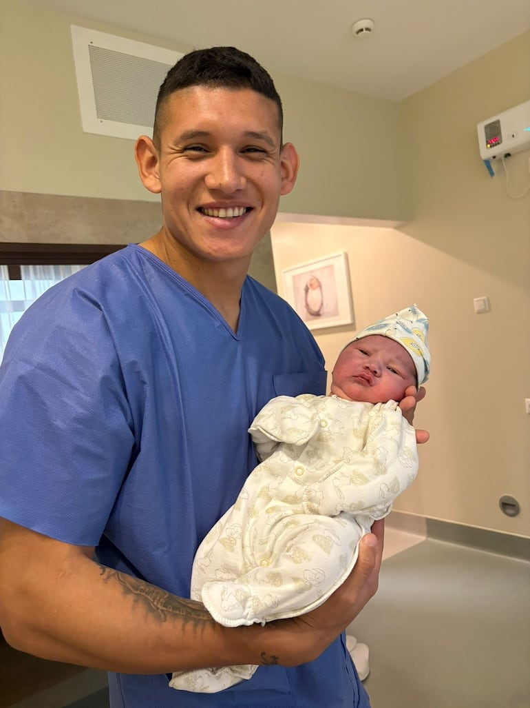 El futbolista Juan Cáceres, feliz con su pequeño Maicol en brazos.