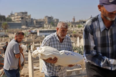 Un hombre lleva en brazos el cadáver de un familiar fallecido en un ataque israelí conta un edificio en la Ciudad de Gaza.