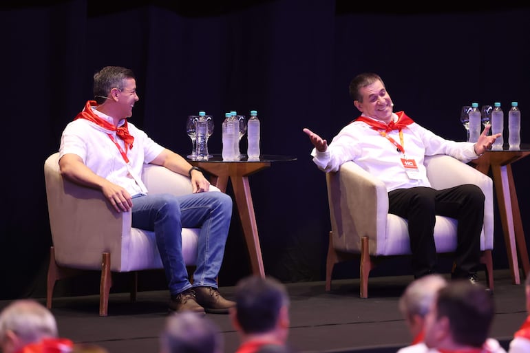 El presidente de Paraguay, Santiago Peña (i) y el expresidente y líder del Partido Colorado, Horacio Cartes (2013-2018), reaccionan durante la plenaria del movimiento político Honor Colorado este sábado, en el Centro de Convenciones de la Conmebol.