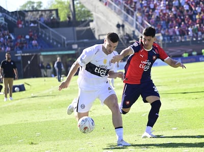 El lateral neozelandés, Timothy John Payne transporta el esférico ante la marca del extremo de Cerro Porteño, Ignacio Aliseda.