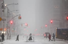 La gente camina por la Sexta Avenida mientras cae nieve en el distrito de Manhattan de la ciudad de Nueva York.