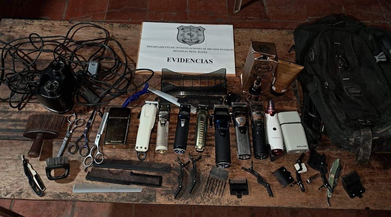 Mesa de madera con cortapelos, tijeras y productos de barbería en un ambiente de oficina de investigaciones.