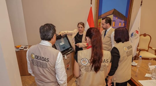 Un grupo de observadores de la OEA escucha explicaciones sobre el sistema electoral en Paraguay.