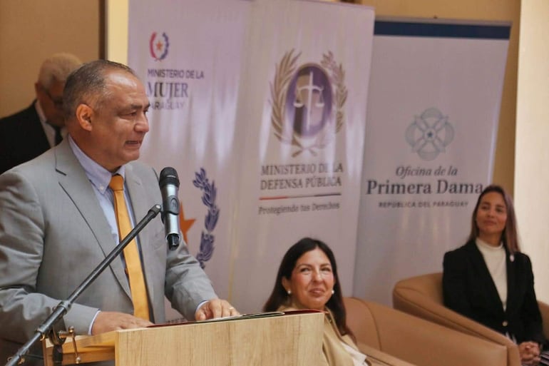 Javier Esquivel en traje gris con corbata amarilla, Alicia Pomata sonriente con abrigo claro, y Antonella Albertini en blazer negro, todos atentos en un evento formal.