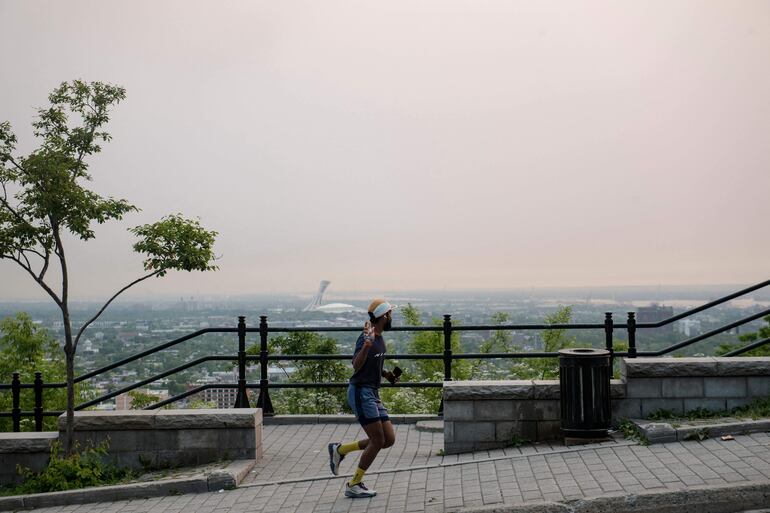 Un corredor corre en Mount Royal mientras Montreal está envuelta en smog el 6 de junio de 2023, en Montreal, Canadá. Environment Canada emitió un aviso de smog por segundo día consecutivo.